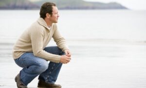 Man Reflecting oMan Reflecting on Beach-Causes Of Alcohol Addiction-TheRiverSource.orgn Shore-Causes Of Alcohol Addiction-TheRiverSource.org